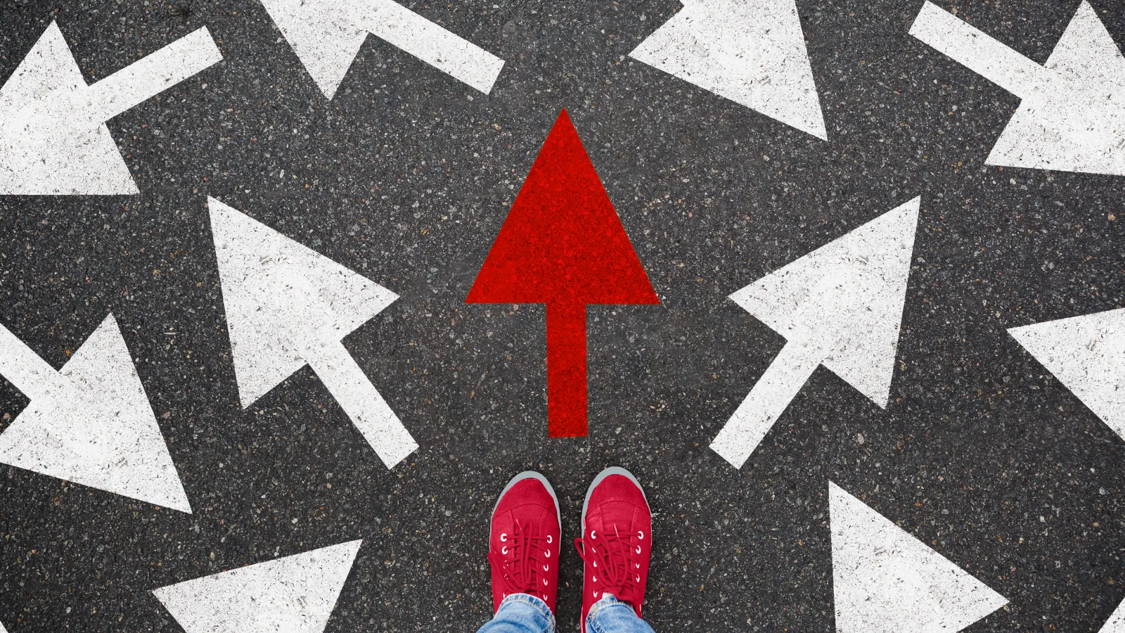 Arrows on the ground going in multiple directions with red feet pointed towards a single red arrow.